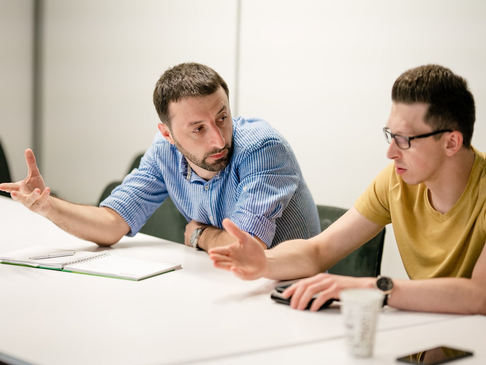 two software testers discussing automation during a meeting - QA