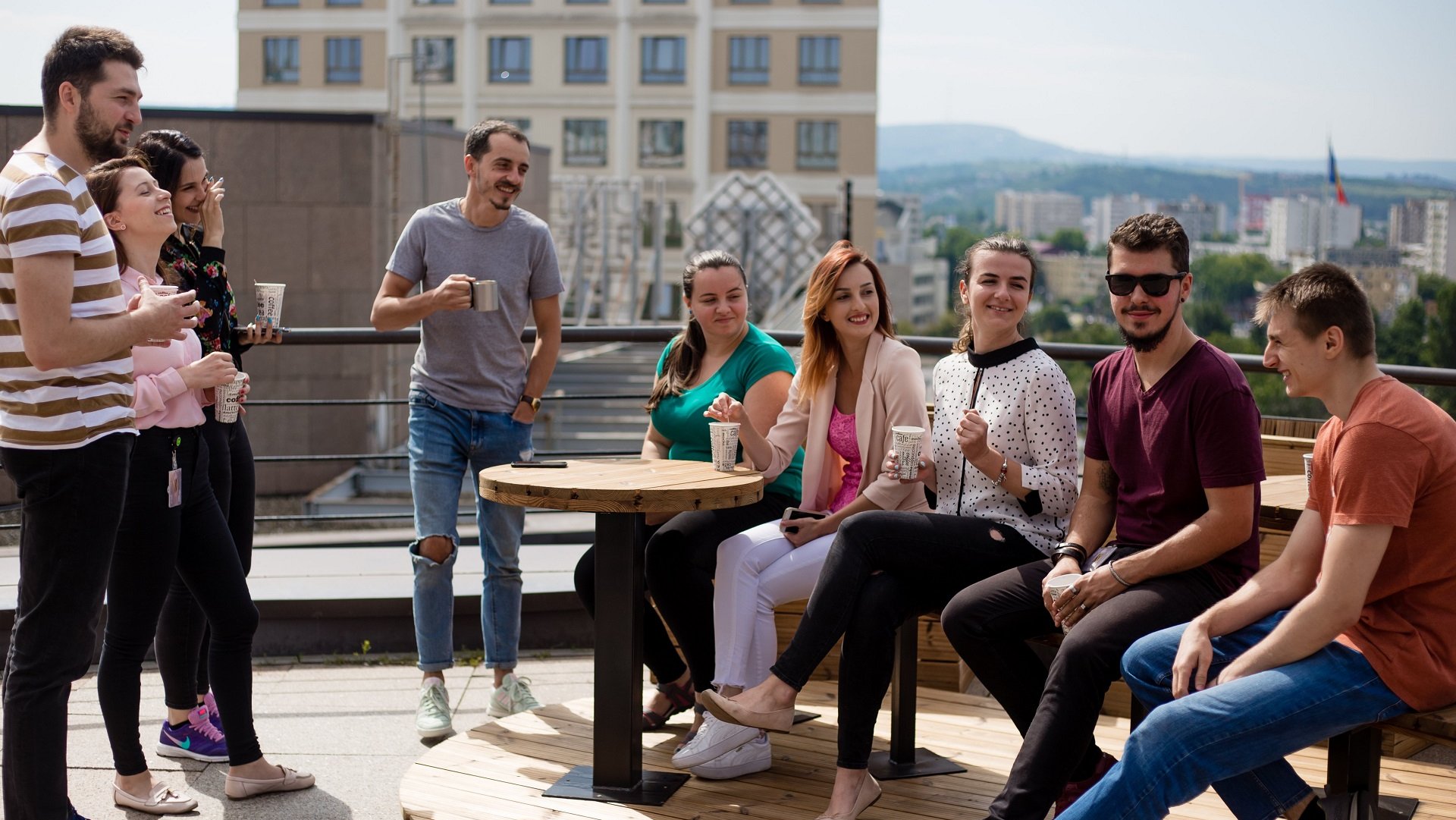 Team of software testers and developers having coffee together on the terrace