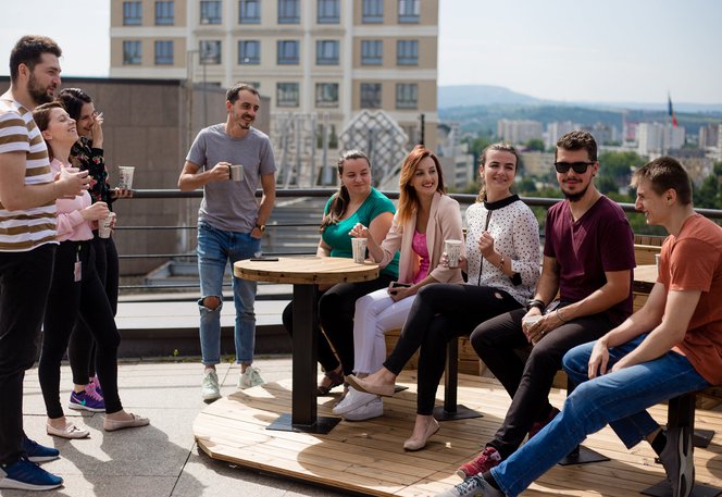 Team of software testers and developers having coffee together on the terrace