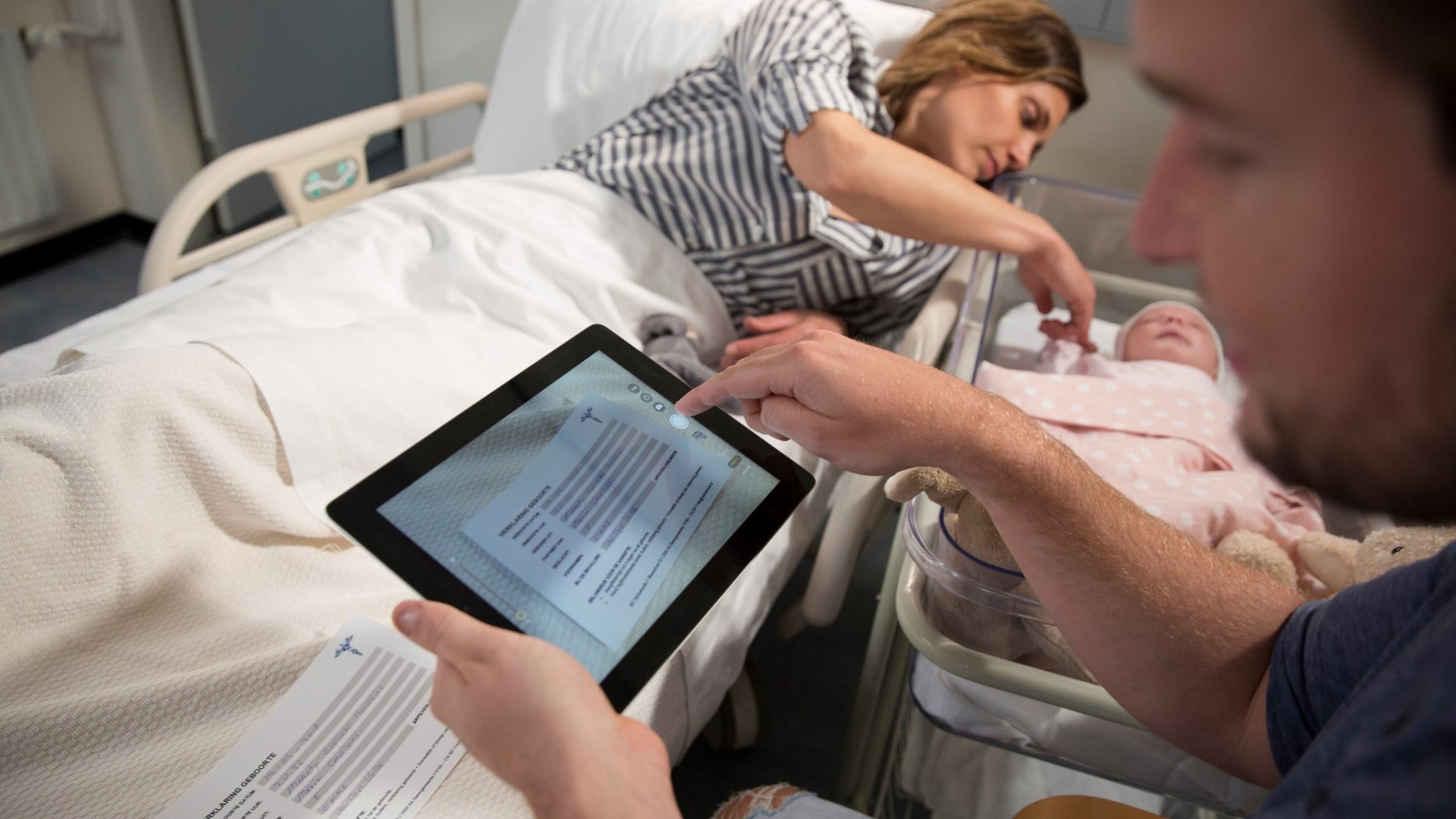 Moeder en vader digitaliseren geboorte aangifte via tablet