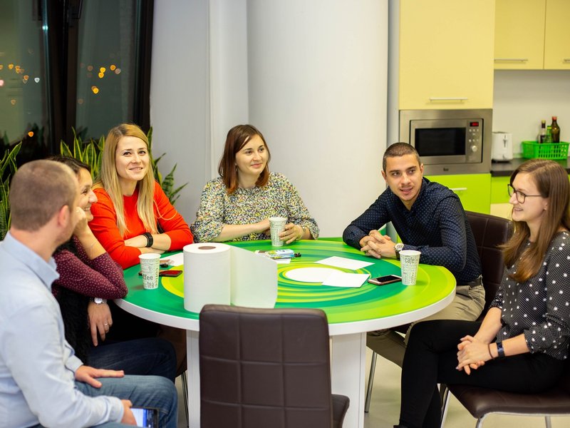 Centric colleagues sitting together talking after work