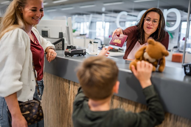 Kind pakt paspoort aan bij de gemeente