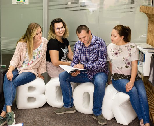 Software testers and software developers in the library reading a book