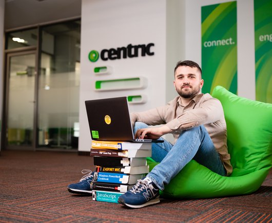 developer working on his computer on a pile of books