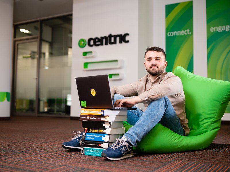 developer working on his computer on a pile of books