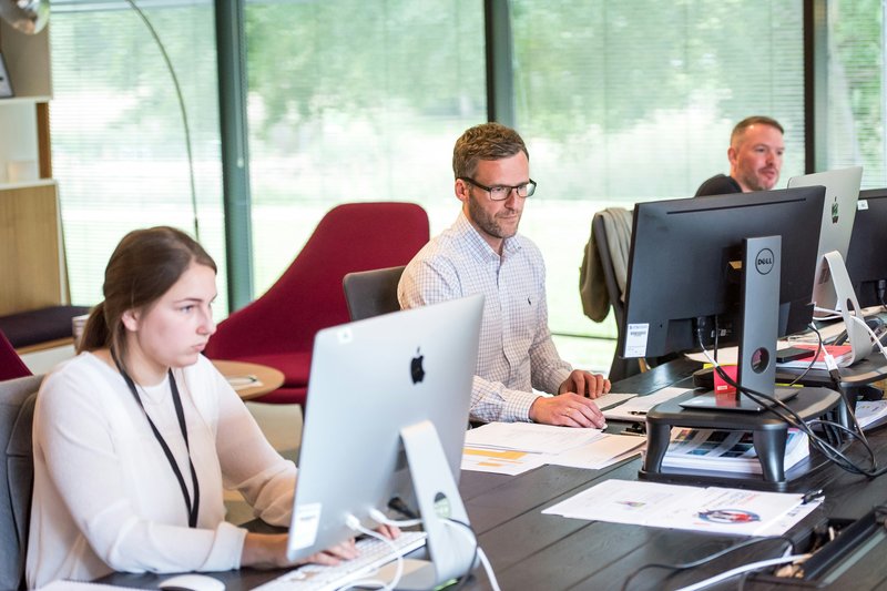 Drie personen aan het werk op de computer omtrent avg