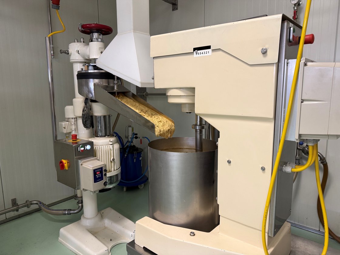 Mosterdproductiemachine bij Mosterdmolen De Huisman, waar grof gemalen mosterd in een roestvrijstalen mengkuip wordt gestort.