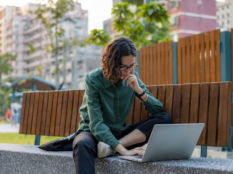 Vrouw kijkt geïnspireerd naar laptop