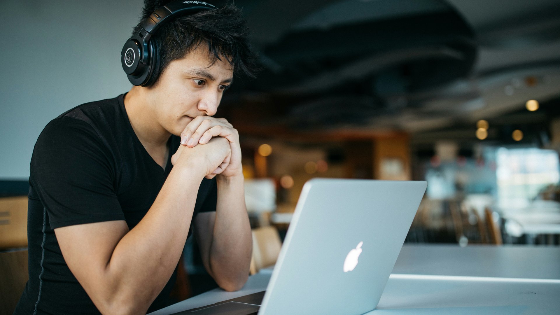 Jongen leest blog achter laptop
