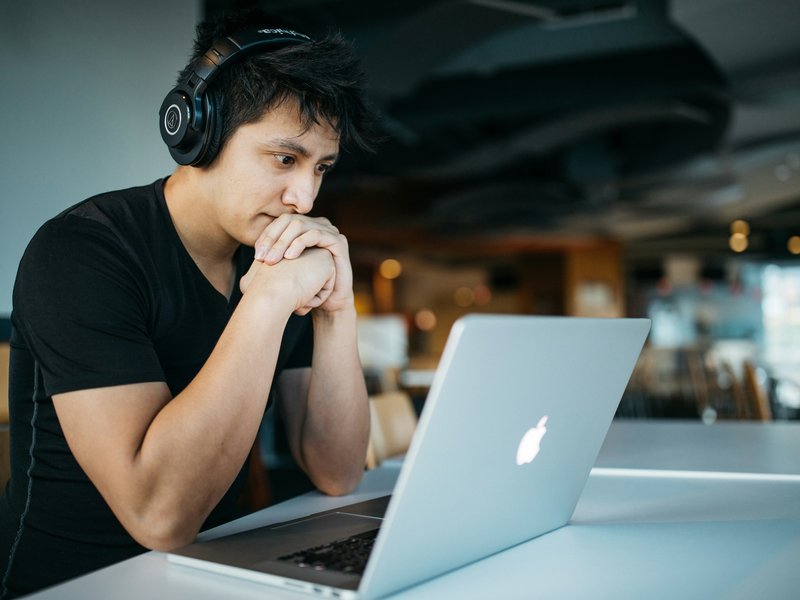 Jongen leest blog achter laptop
